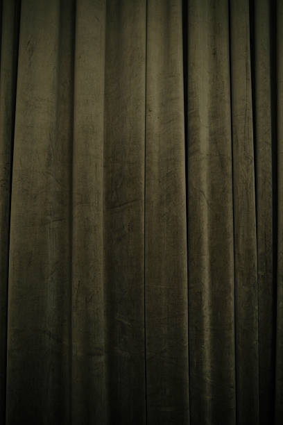 istock Rich dark green velvet curtains with vertical folds creating a dramatic textured background for events. 2250903407