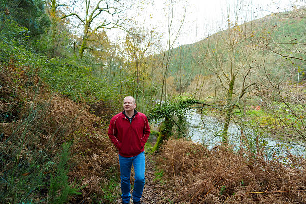 istock Man walking forest trail along river enjoying nature 2250903645