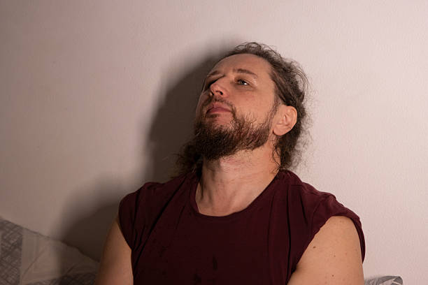 istock Young man looking up with pensive expression against wall 2250905291