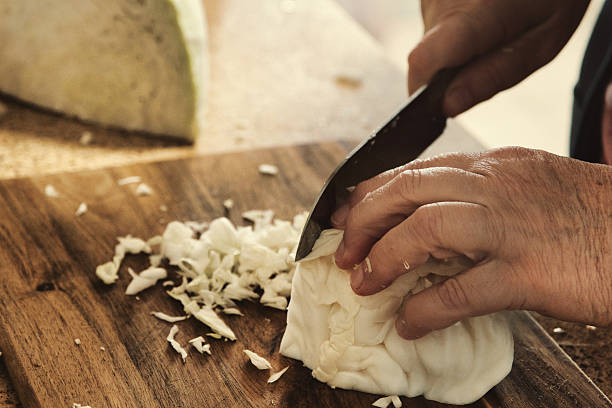 istock Close-Up of Hands Shredding Cabbage on Wooden Cutting Board 2250909741