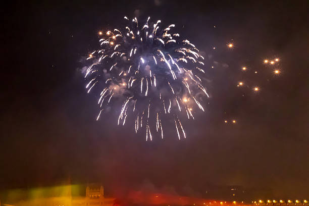 A spectacular burst of blue fireworks lights up the dark night sky, creating a dazzling display of light and color. The glowing sparks radiate in all directions, filling the atmosphere with a festive and celebratory mood. The blue tones and bright intensity highlight the grandeur of the event.