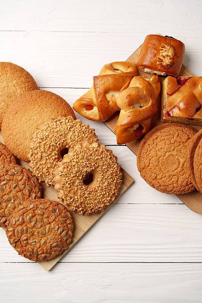 Various types of baked cookies and pastries arranged on wooden platters for a delightful dessert display