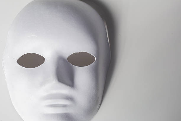 istock White mask resting on a gray surface, highlighting simplicity and mystery in design 2250915696