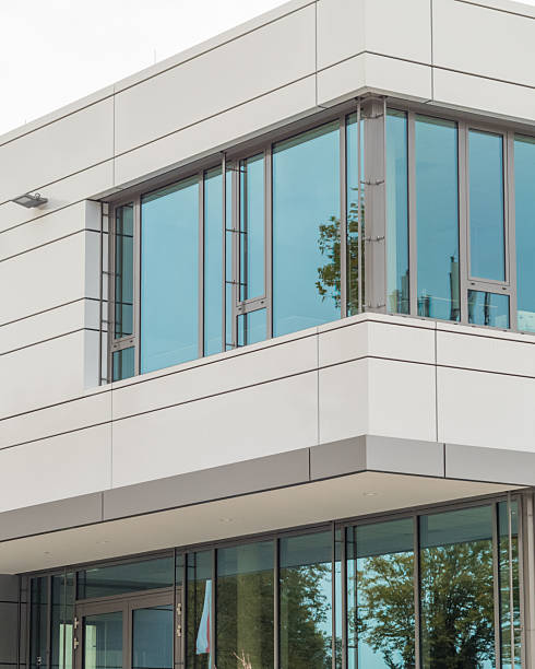 istock Modern office building exterior with glass windows reflecting blue sky 2250923252