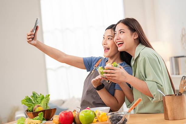 istock Friends enjoy cooking and taking selfies while preparing a meal in a bright kitchen in the afternoon 2250924371