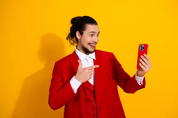 istock Funny stylish guy in red suit posing for a bright selfie on a bold yellow backdrop a playful fashion moment for promotion and celebration 2250927075