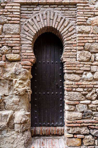 istock Ancient Arched Wooden Door in Stone Wall 2250927825