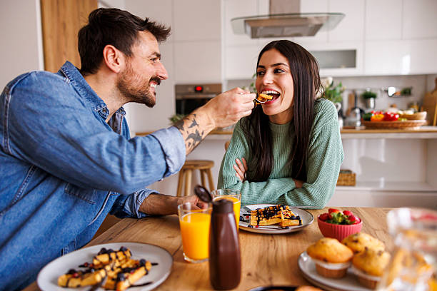 istock Couple feeding each other while having breakfast at home 2250927956