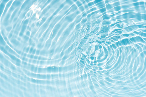 istock Blue water with ripples on the surface. Defocus blurred transparent blue colored clear calm water surface texture with splashes and bubbles. Water waves with shining pattern texture background. 2250928386