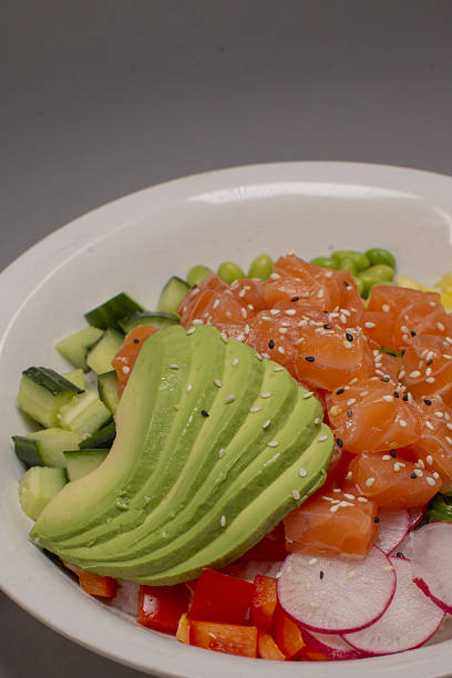 Delicious and colorful salmon poke bowl with fresh garden vegetables