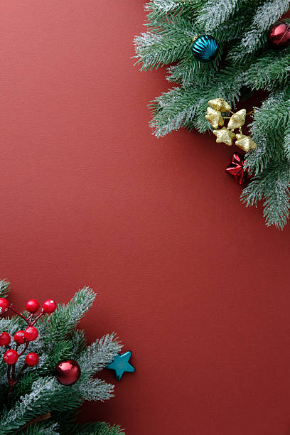 istock Minimalist vertical red Christmas background with frosted pine branches, baubles, and holly berries. 2250937595