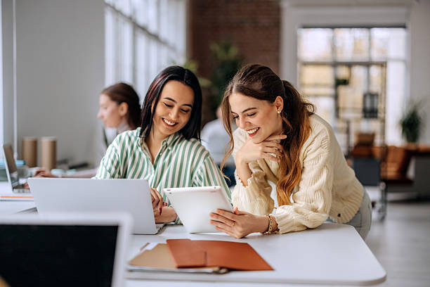 istock Two businesswomen working on digital tablet in office 2250940439