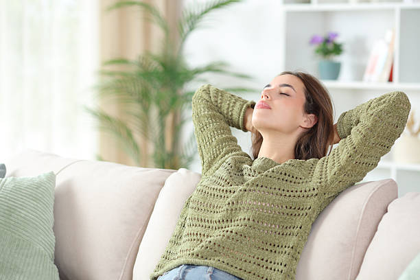 istock Relaxed woman in green resting sitting on a sofa 2250940485