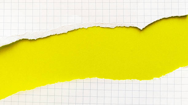 istock Ripped white paper with squared texture on a bright yellow background. The torn edge creates a contrast between the two colours. 2250942741