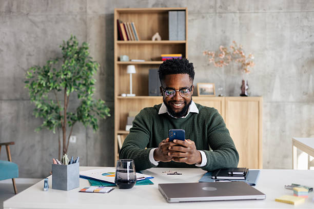 istock African american man smiling using smartphone in modern office 2250942897