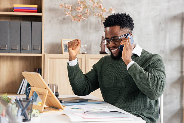 istock Black man celebrating success during phone call at desk 2250942907