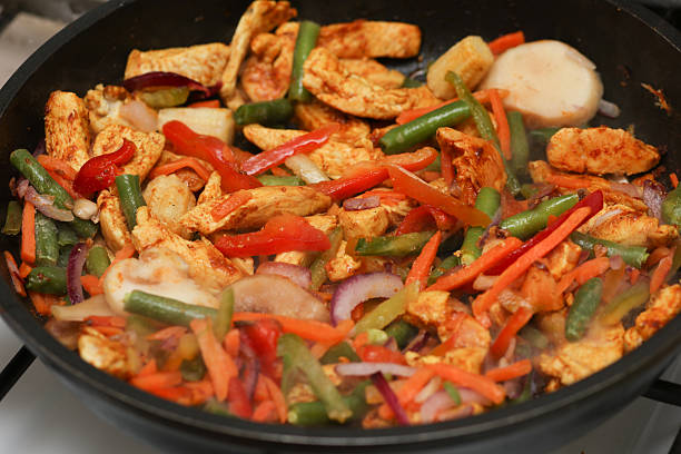 cooking vegetables in a coated pan on a gas stove