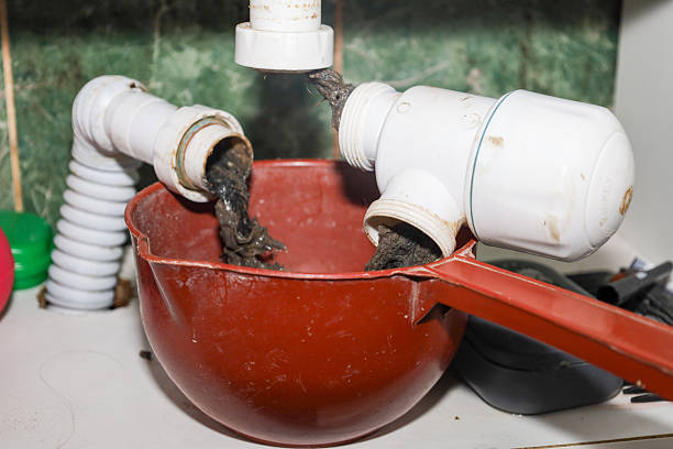istock Disassembling a sink siphon, from which accumulated dirt, hair, and other waste causing a blockage are being pulled out. This frame illustrates plumbing work, the necessity of cleaning the drain, and dealing with household problems. 2250945952