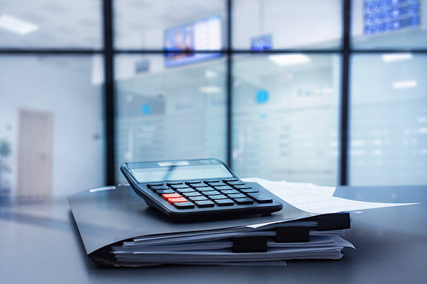 istock Black calculator on a stack of business documents and a dark folder in modern corporate office bank. Concept financial management, accounting and professional planning. 2250948023