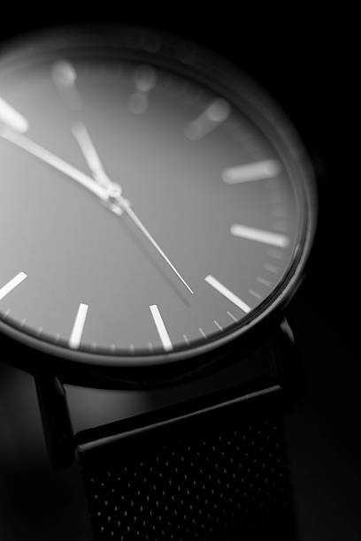 istock Minimalist wristwatch close-up: sleek silver dial, precise hands, and elegant black background 2250949991