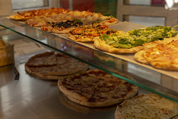 Display of different pizzas with fresh toppings and inviting ambiance