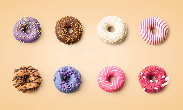 istock Colorful donuts with various toppings on a plain background arranged in rows 2250953022