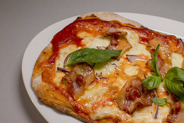 smoky bacon pizza with caramelized onion and melted mozzarella, basil accents and golden crust, hearty brunch or dinner option