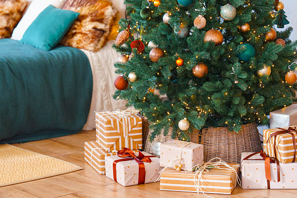 istock Christmas tree with gift boxes, presents in bedroom. Festive decorations with wrapped gifts near bed 2250954105