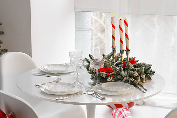 istock Festive Christmas table setting with frosted pine branches, candles, and white plates on round table 2250954125