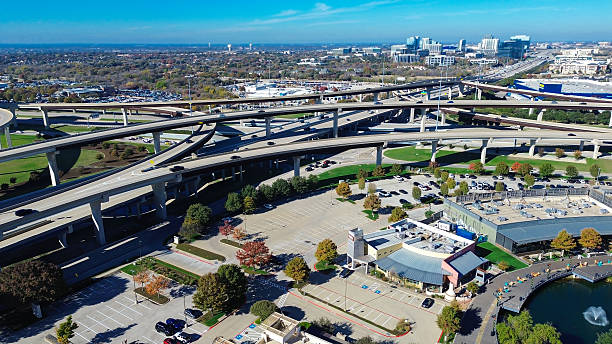 istock Highway junction connects multiple elevated lanes with retail anchors, large-format stores, structured parking, pedestrian-friendly commercial area, pondside restaurant outdoor seating, Plano, TX 2250958960