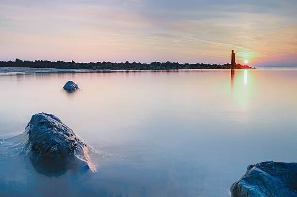 istock Golden sunset paints tranquil seascape with ethereal glow and foreground rocks. 2250959306