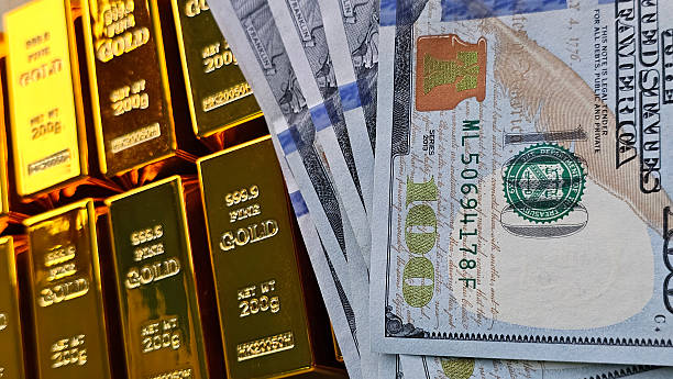 istock Gold bars and dollar bills displayed together in a financial setting 2250959389