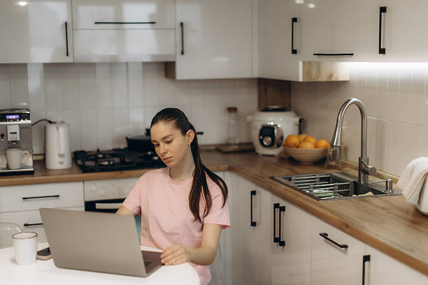 istock Woman Working on Laptop in Modern Kitchen with Minimalistic Design 2250961264