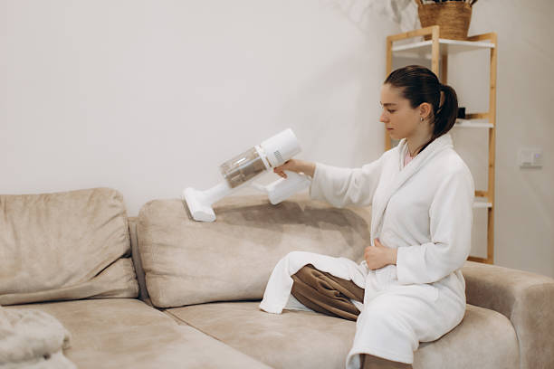 istock Woman Cleaning Sofa With Modern Vacuum Cleaner at Home in a Relaxed Setting 2250961270