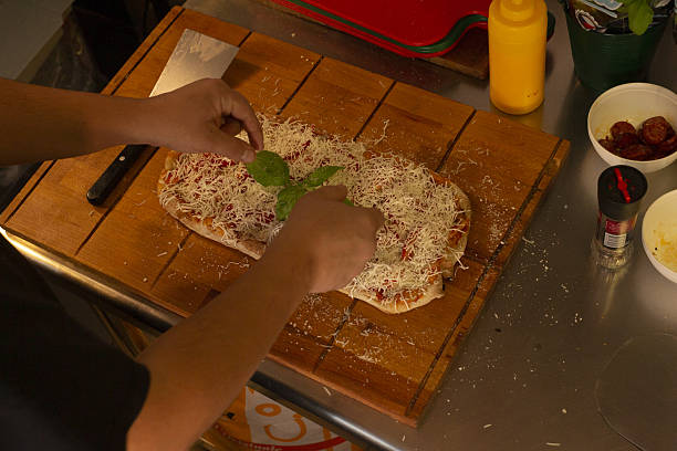 istock Warmly lit scene showing handcrafted Margherita pizza being finished 2250961607