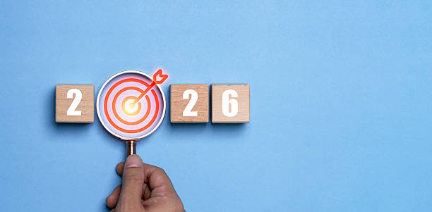 istock Hand holding magnifying glass highlighting a target icon between the numbers 2026 represents a happy new year with focus goal setting motivation precision planning and direction for future success. 2250962432