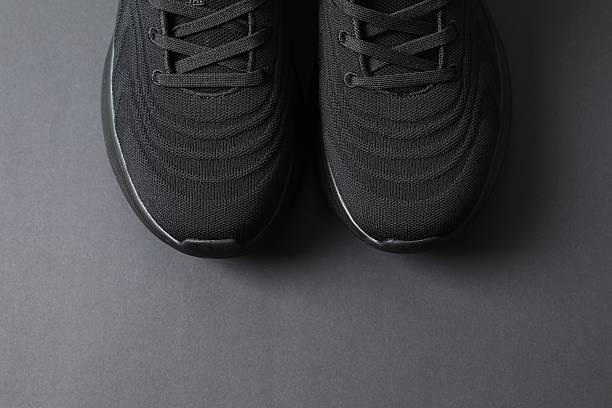 istock Pair of stylish sneakers on a black background 2250963851