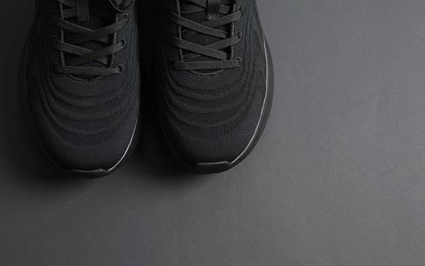 istock Pair of stylish sneakers on a black background 2250963856