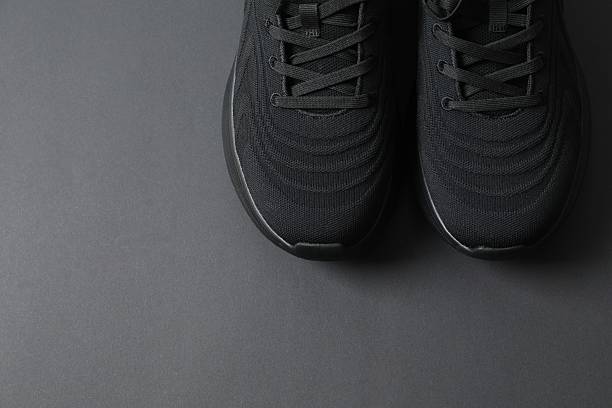 istock Pair of stylish sneakers on a black background 2250963864