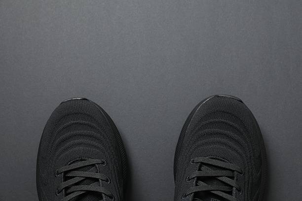 istock Pair of stylish sneakers on a black background 2250963882