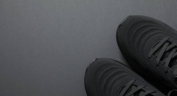 istock Pair of stylish sneakers on a black background 2250963885