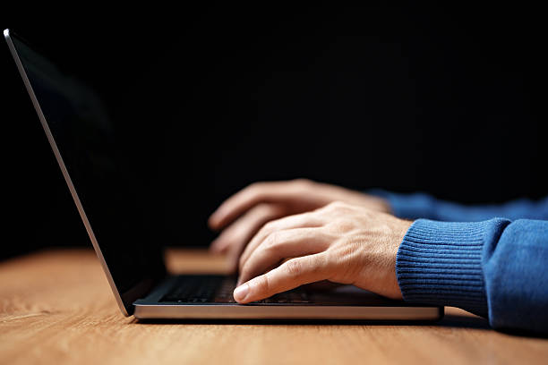 istock Hands typing on a laptop during evening work session in a dimly lit workspace 2250965364