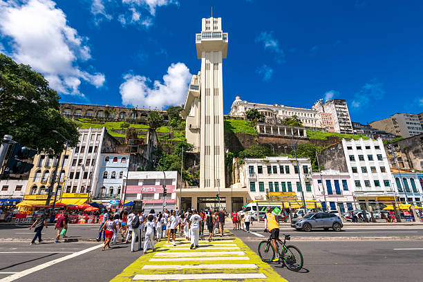 Salvador, Brazil - July 27, 2025: Group of people crossing the street and walking towards the Lacerda elevator which brings to the upper part of the city.
