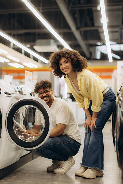 istock Smiling Couple Shopping for a Washer in an Electronics Store 2250968515