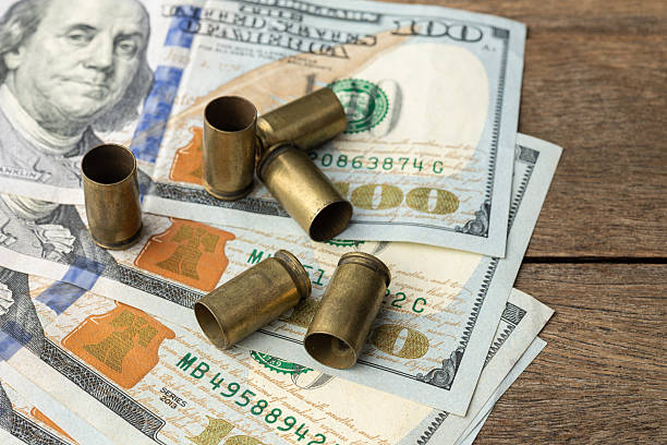 istock Used old ammunition casings over dollar bills 2250969323