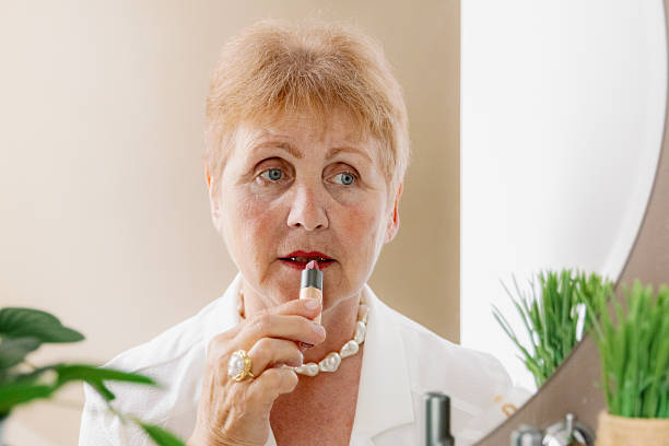 istock One elderly stylish woman paints her lips with natural lipstick. 2250970055
