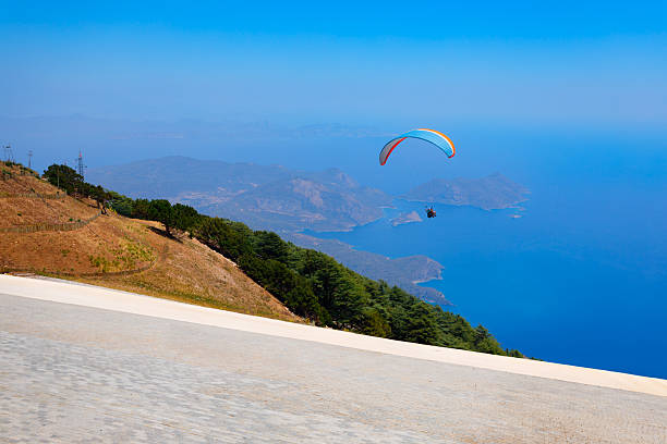 Flying paraglider at the top of Babadag mountain in Turkey. Oludeniz or Blue Lagoon is a beach resort in the Fethiye district of Mugla Province, Turkey.