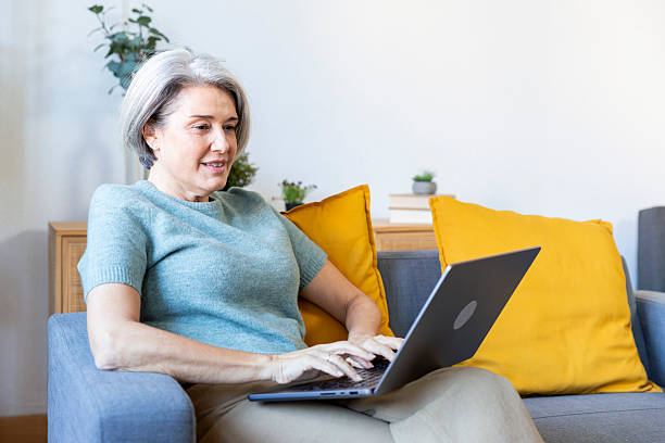 istock Mature woman working remotely on laptop at home 2250970752