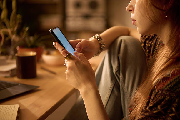 istock Young Woman Using Smartphone While Sitting at Desk Indoors 2250975453