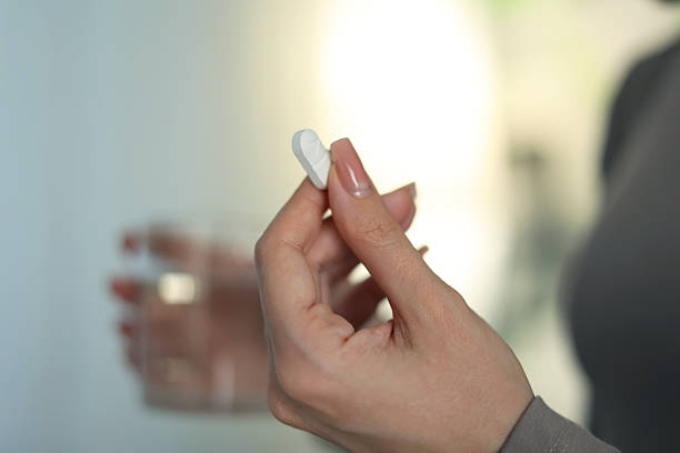 istock Taking Medication An InDepth Close Up View of Various Pills and Water for Hydration 2250977374